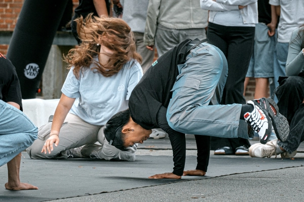 Unge laver Breakdance på gårdspladsen.